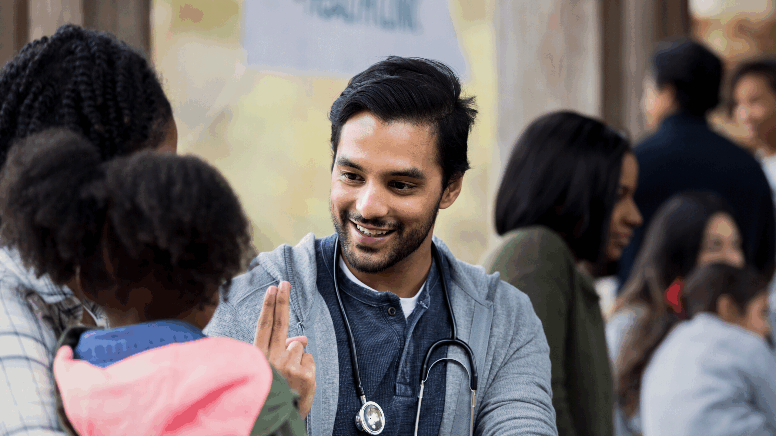 Smiling healthcare worker interacting with a child at a community health event.